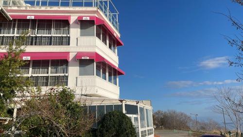 een hoog gebouw met een roze en witte bij iskele rum butik otel in Tekirdag