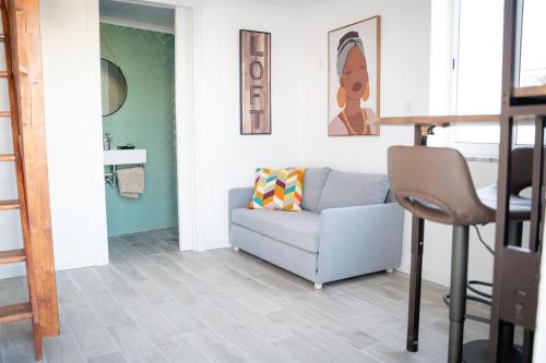 a living room with a couch and a chair at Riad'a Praia in Armação de Pêra