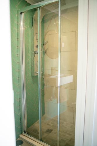 a glass shower in a bathroom with a sink at Riad'a Praia in Armação de Pêra