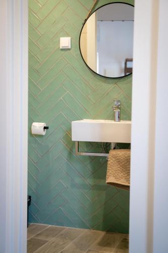 a bathroom with a sink and a mirror at Riad'a Praia in Armação de Pêra