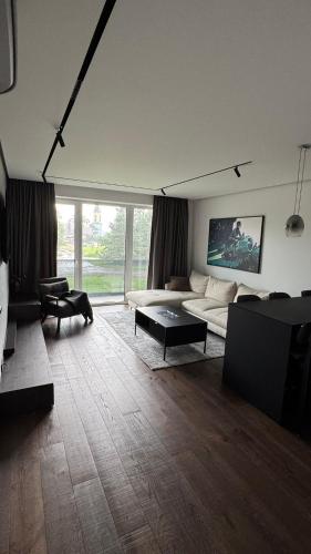 Ziogu Apartments في بالانغا: غرفة معيشة بها أريكة وطاولة