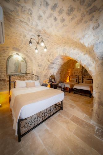 a bedroom with a bed and a stone wall at AURA TAŞ Hotel in Urfa