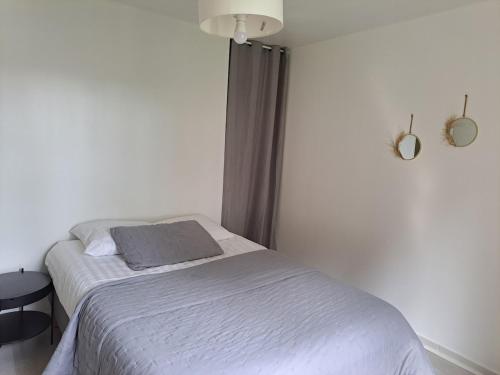 a bedroom with a bed with a gray blanket at La Pomme d'Or Maison 8 personnes in Sainte-Opportune-la-Mare