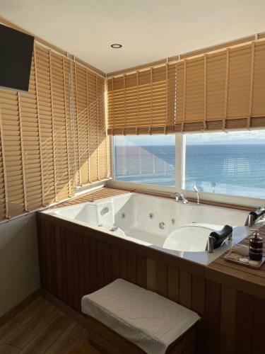 een badkamer met een bad, een wastafel en een raam bij iskele rum butik otel in Tekirdag