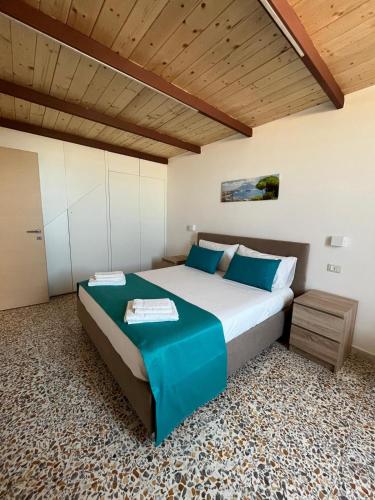 a bedroom with a large bed and a wooden ceiling at Nello House in Vico Equense