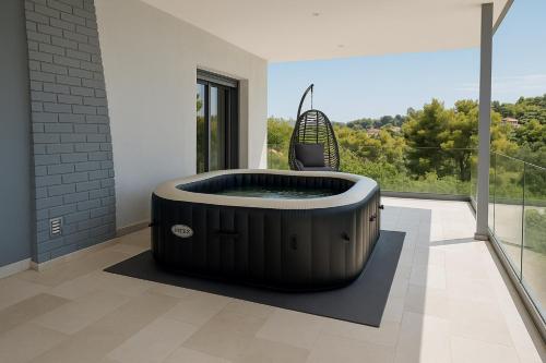 a hot tub in a room with a window at Jasmin House - Sea view - In town in Skála Oropoú