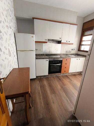 a kitchen with white appliances and a wooden floor at El Jazmín in San Vicente del Raspeig