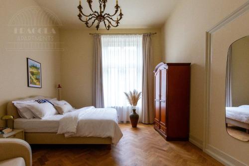 a bedroom with a bed and a window and a chandelier at Fragola Apartments Old Town in Kraków