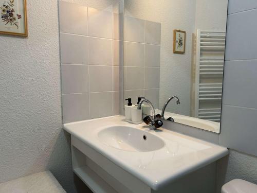 une salle de bain blanche avec un lavabo et un miroir dans l'établissement Appartement Confortable 6 Pers, Montgenèvre, Parking, Casier à Skis, Animaux Bienvenus - FR-1-330D-93, à Montgenèvre