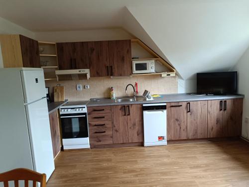 a kitchen with wooden cabinets and white appliances at Ubytování Mirka in Vítkovice