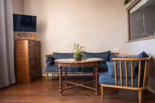 a living room with a blue couch and a table at Beit Oren Hotel in Bet Oren