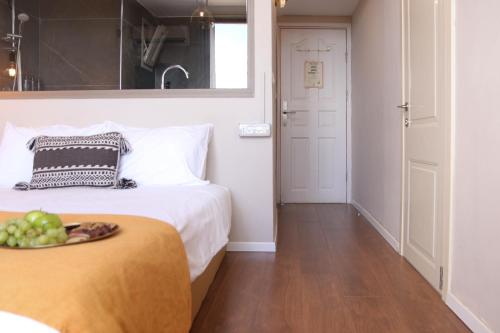 a bedroom with a bed and a bowl of fruit on a plate at Beit Oren Hotel in Bet Oren