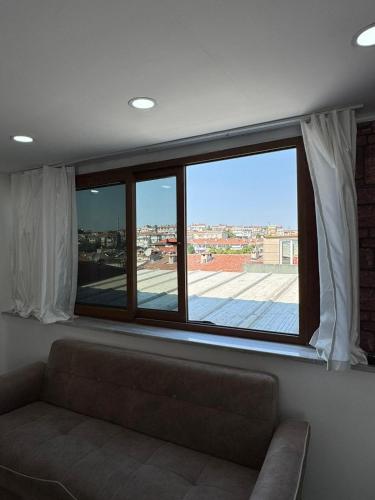 a living room with a couch and a large window at beyzade apart hotel in Istanbul