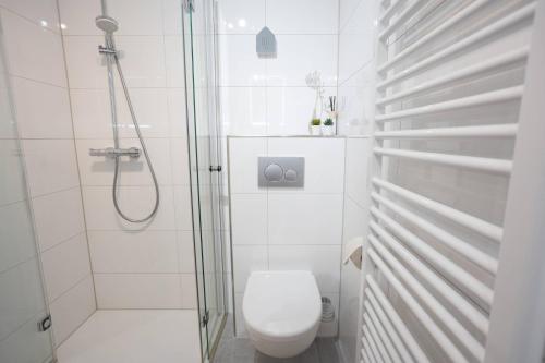 a white bathroom with a toilet and a shower at Ferienwohnung "Kirchblick" im Ferienhaus Blumenhain in Bad Wünnenberg