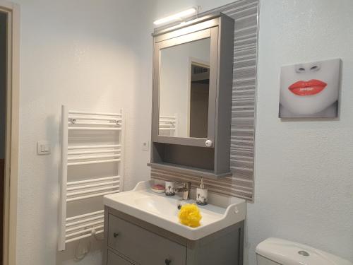 a white bathroom with a sink and a mirror at Casa di u sole in Santa-Maria-Poggio
