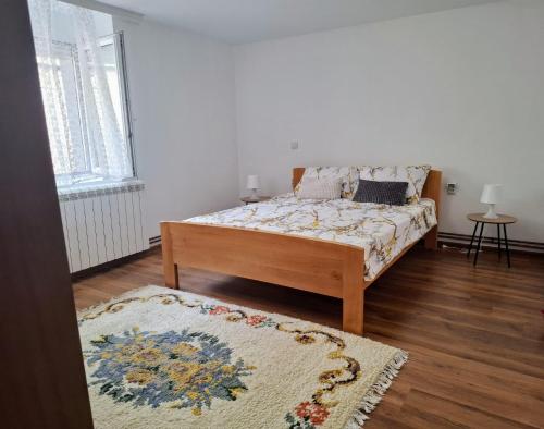 a bedroom with a bed and a rug at Home Well Apartman Vranje in Vranje