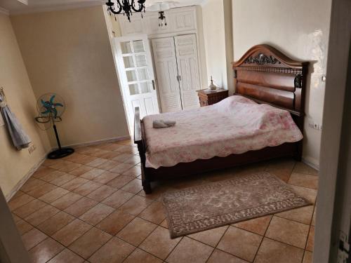 a bedroom with a bed and a rug on the floor at Villa mouna in Mohammedia