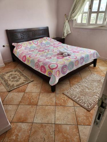 a bed in a bedroom with two rugs on the floor at Villa mouna in Mohammedia