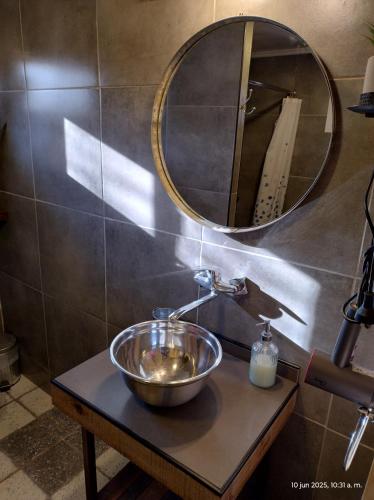 a bathroom with a sink and a mirror on a table at La Vieja Finca in Ciudad Lujan de Cuyo