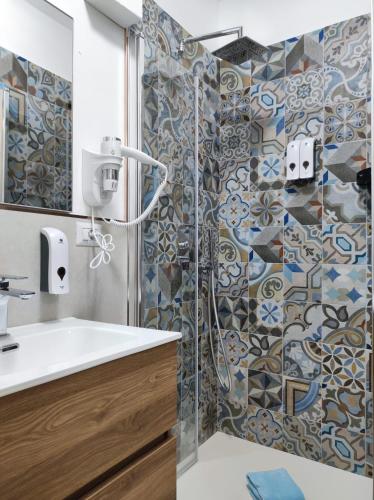 a bathroom with a shower and a white sink at Mar&Mar in Alghero