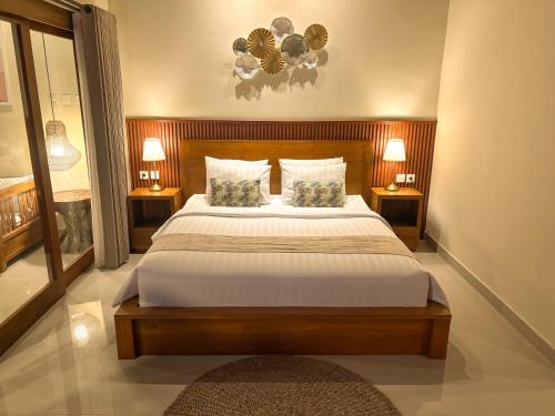 une chambre avec un grand lit avec deux lampes dans l'établissement Uma Phala Villa, à Ubud