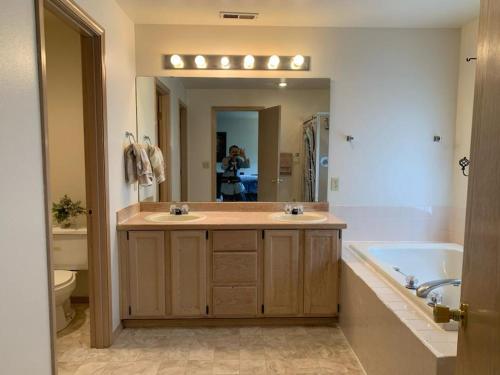 a bathroom with a sink and a tub and a mirror at Cedar River one bedroom in a four bedroom house in Renton