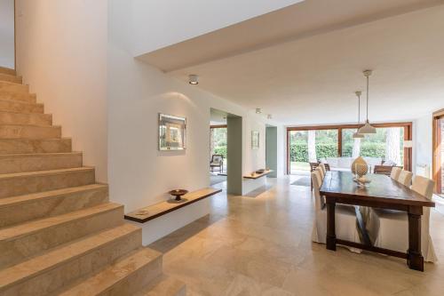 a living room with a dining room table and stairs at Villa Dei Pini in Casa Mora