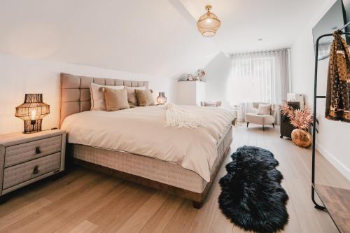 a bedroom with a large bed with a black dog laying on the floor at Maison Idyllique in Bree