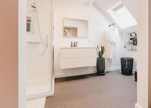 a white bathroom with a sink and a shower at Maison Idyllique in Bree
