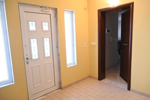 a hallway with a white door and a bathroom at Garden Bliss 1 Alexandroupolis in Alexandroupoli