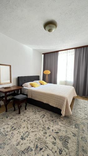 a bedroom with a bed and a table and a window at Guest House Bosnian House in Sarajevo