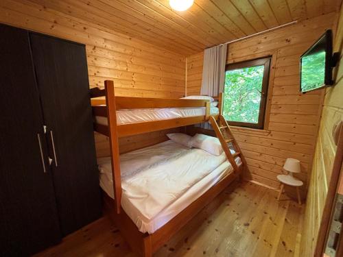 a bedroom with two bunk beds in a log cabin at Domki Bałtyku Szept in Darłowo