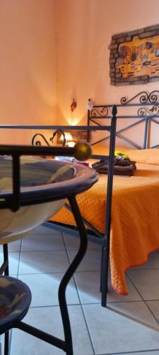 a bedroom with a bed with a table and a chair at Elìsim House in Caiazzo