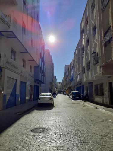 an empty street with a car parked in the middle at Dar Al-Amira - Fnideq Beach Apartment in Fnidek