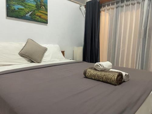 a bed with a pillow and towels on it at The Iris Volcano in Kubupenlokan