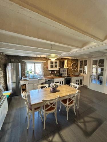 a large kitchen with a wooden table and chairs at Casa del Castell de Toloriu in Toloríu