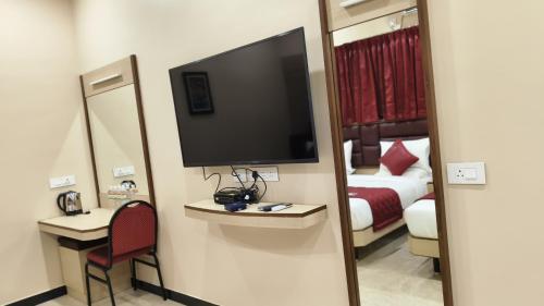 a hotel room with a television and a bed at Majestic Hotel in Madurai