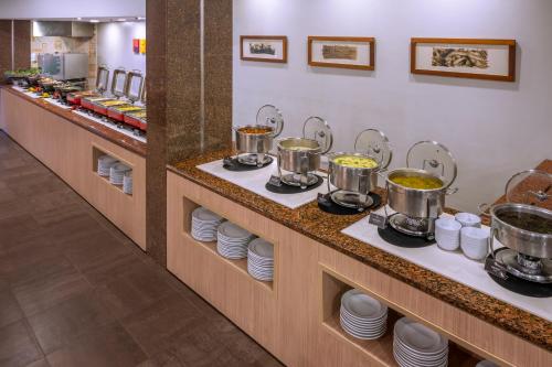 a buffet line with pots and pans of food at SERHS Experience Suítes in Natal