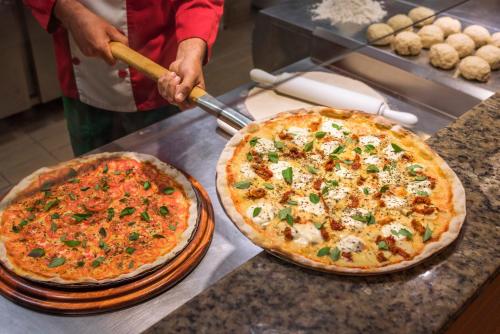 two pizzas sitting on top of a counter at SERHS Experience Suítes in Natal