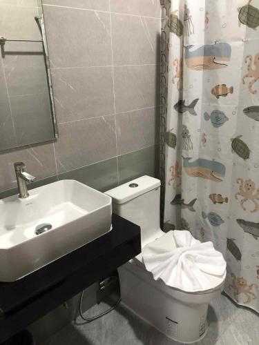 a bathroom with a sink and a toilet and a mirror at Borrii House โบ ลี่ เฮาท์ in Layan Beach