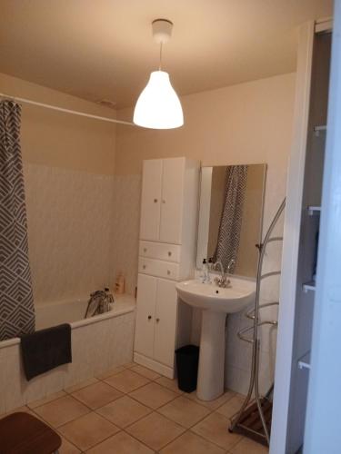 a bathroom with a sink and a bath tub at La Ferme 3 in Arinthod