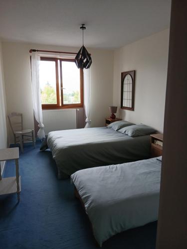 a group of three beds in a room with a window at La Ferme 3 in Arinthod