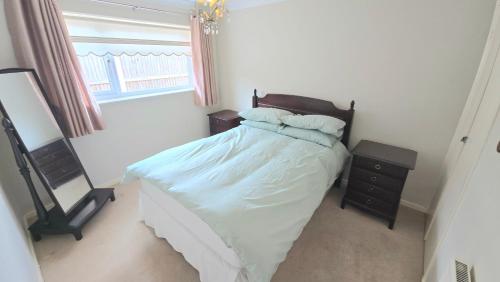 een slaapkamer met een bed, een spiegel en een raam bij Herne Bay - House - Sleeps 7 - Parking in Herne Bay
