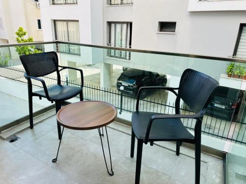 two chairs and a table on a balcony with a car at North Residence Havuz Manzaralı Daire in Kérynia