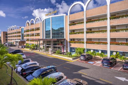 a parking lot with cars parked in front of a building at SERHS Experience Suítes in Natal