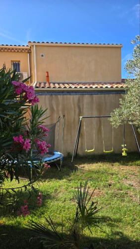 a yard with a fence and a bench and flowers at PROVENCE, MAISON SPACIEUSE et CONFORTABLE CLOSE TO SPIROU , WAVE ISLAND in Monteux