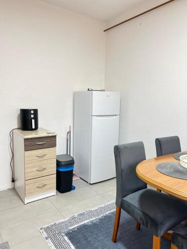 a kitchen with a table and a white refrigerator at Guest House Bosnian House in Sarajevo