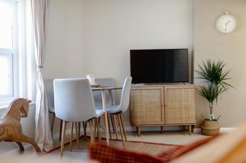 a living room with a table with chairs and a tv at Flat in Arundel in Arundel