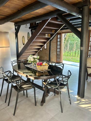 a dining room with a black table and chairs at Celeiro Herzland in Pomerode