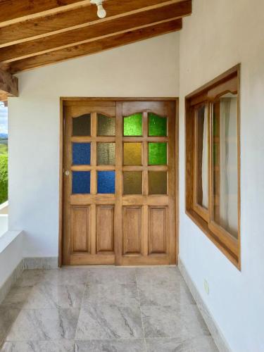 a wooden door in a room with a window at Finca Completa Carmen Viboral Naturaleza y Privacidad in Carmen de Viboral